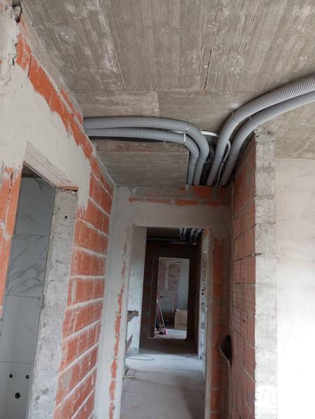 Corredor em obra, tubagem à vista